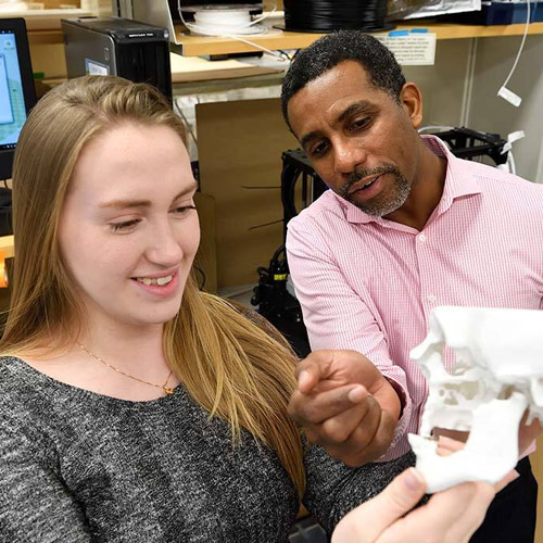 A student and a professor inspecting a skull